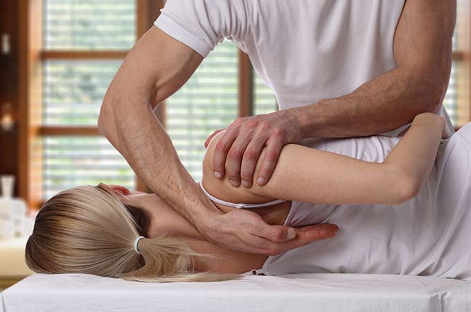 Chiropractor giving chiropractic treatment to female patient