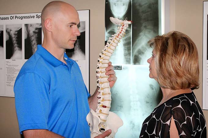 Dr. Cain discussing chiropractic treatment with patient