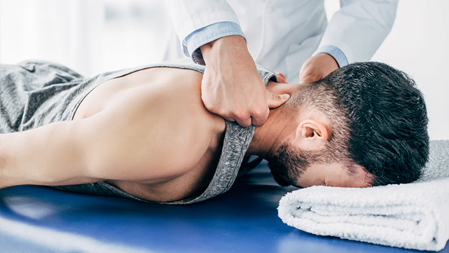 Man laying on stomach and getting a chiropractic adjustment