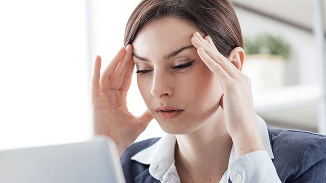 Women putting her hands to her head due to a headache