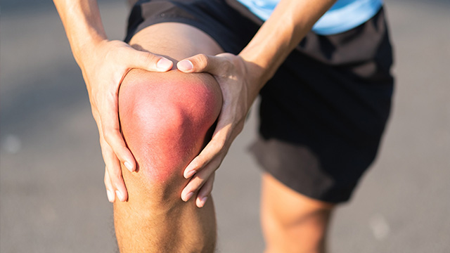 Athlete holding sore knee due to injury