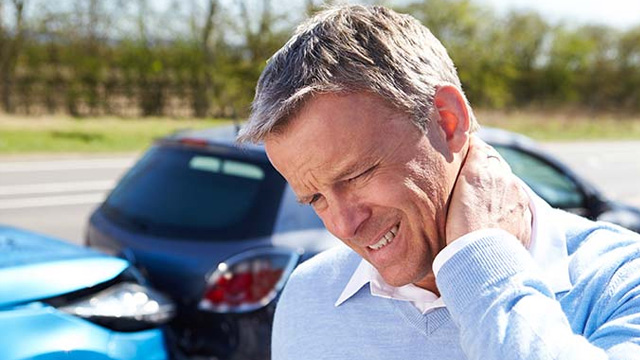 Man holding his neck in pain after whiplash injury